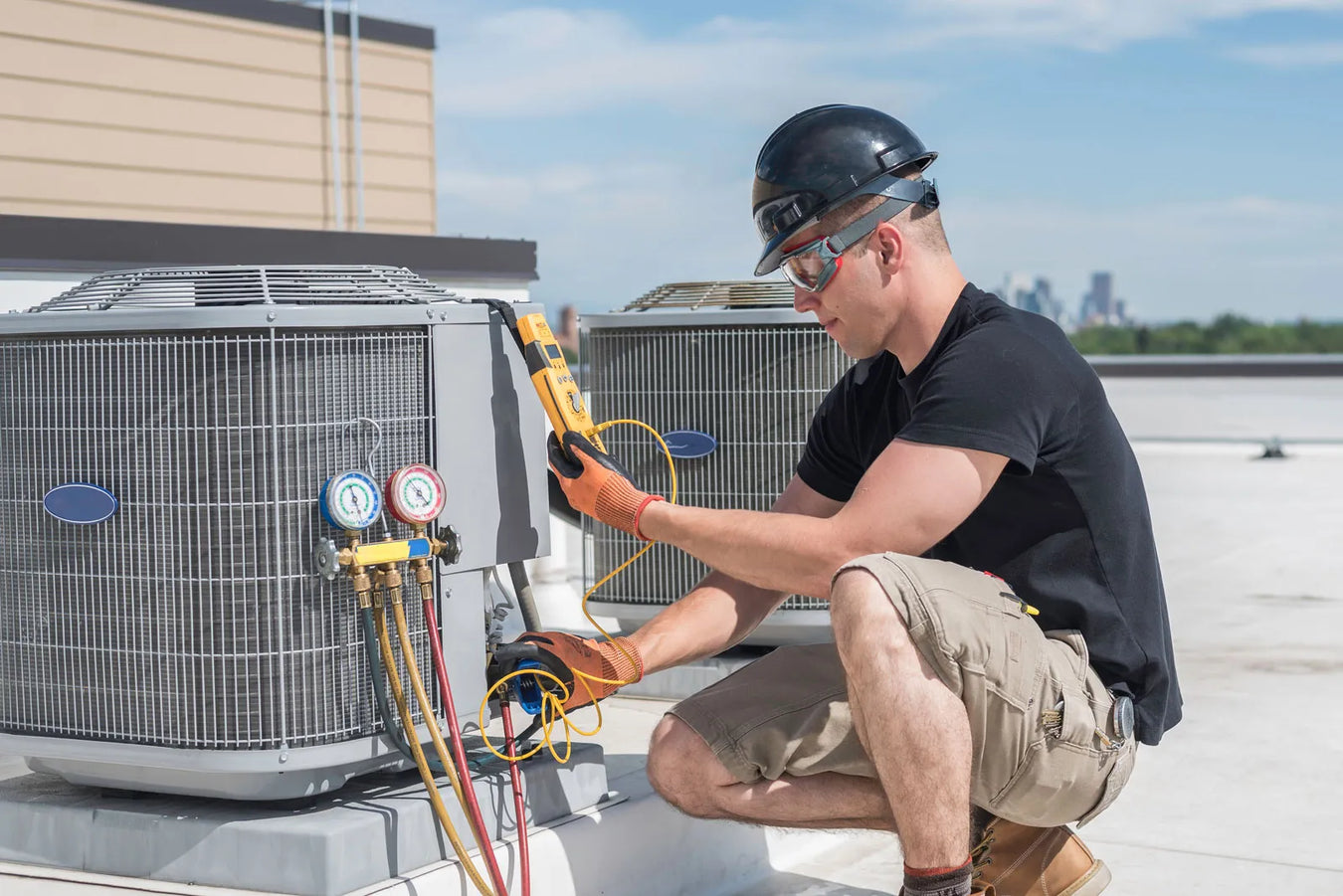 A male blue-collar worker operating an HVAC system, installing a condensate pump.